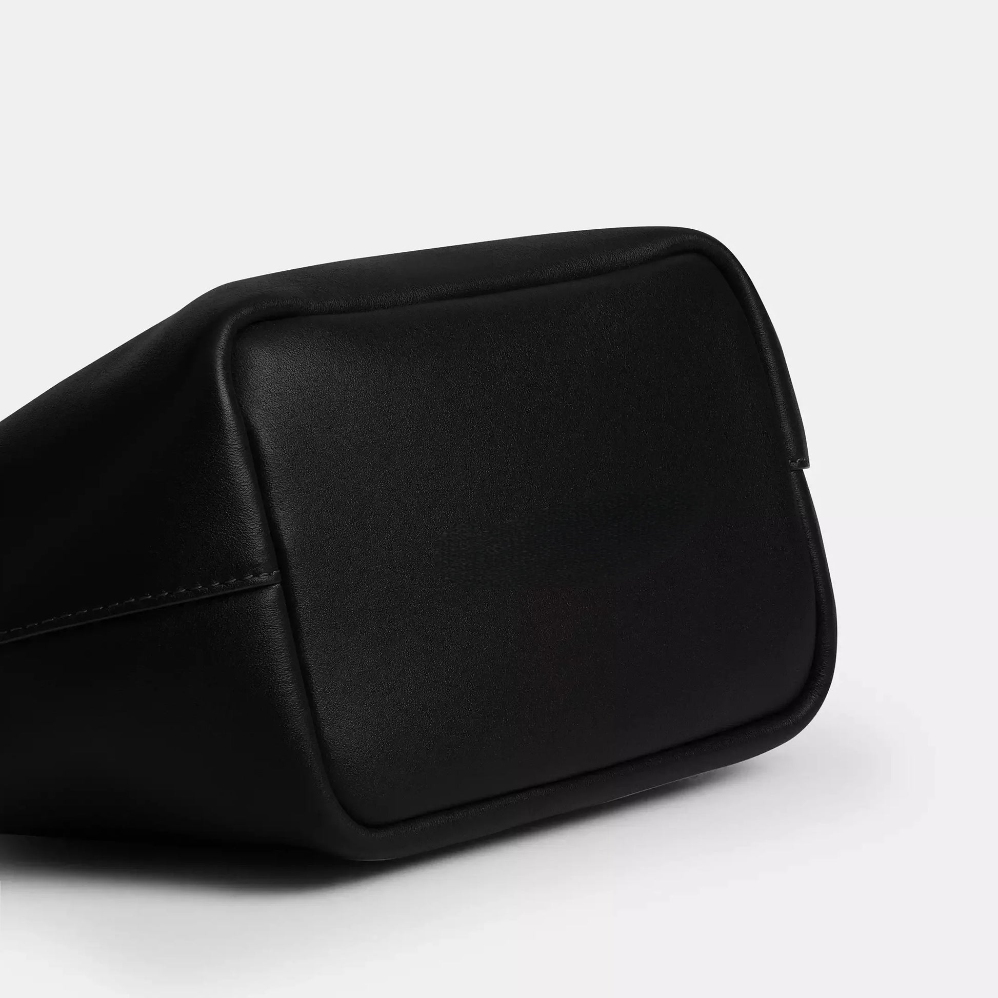 Edenista black microfibre leather kiss-lock top-handle clutch bag close-up corner