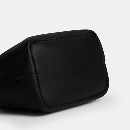Edenista black microfibre leather kiss-lock top-handle clutch bag close-up corner
