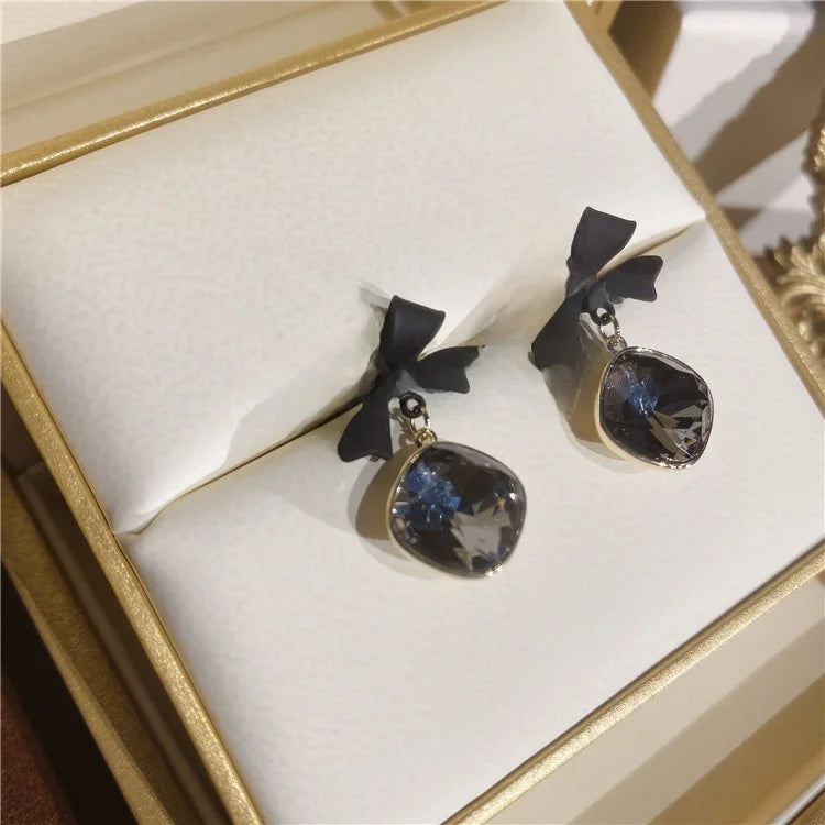 Edenista black bow tie stud earrings with round dark gemstone, gold-tone alloy setting, pair in box