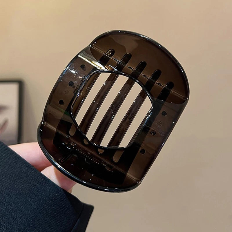 Dark brown translucent flat crab hair clip with curved frame and bar-style teeth