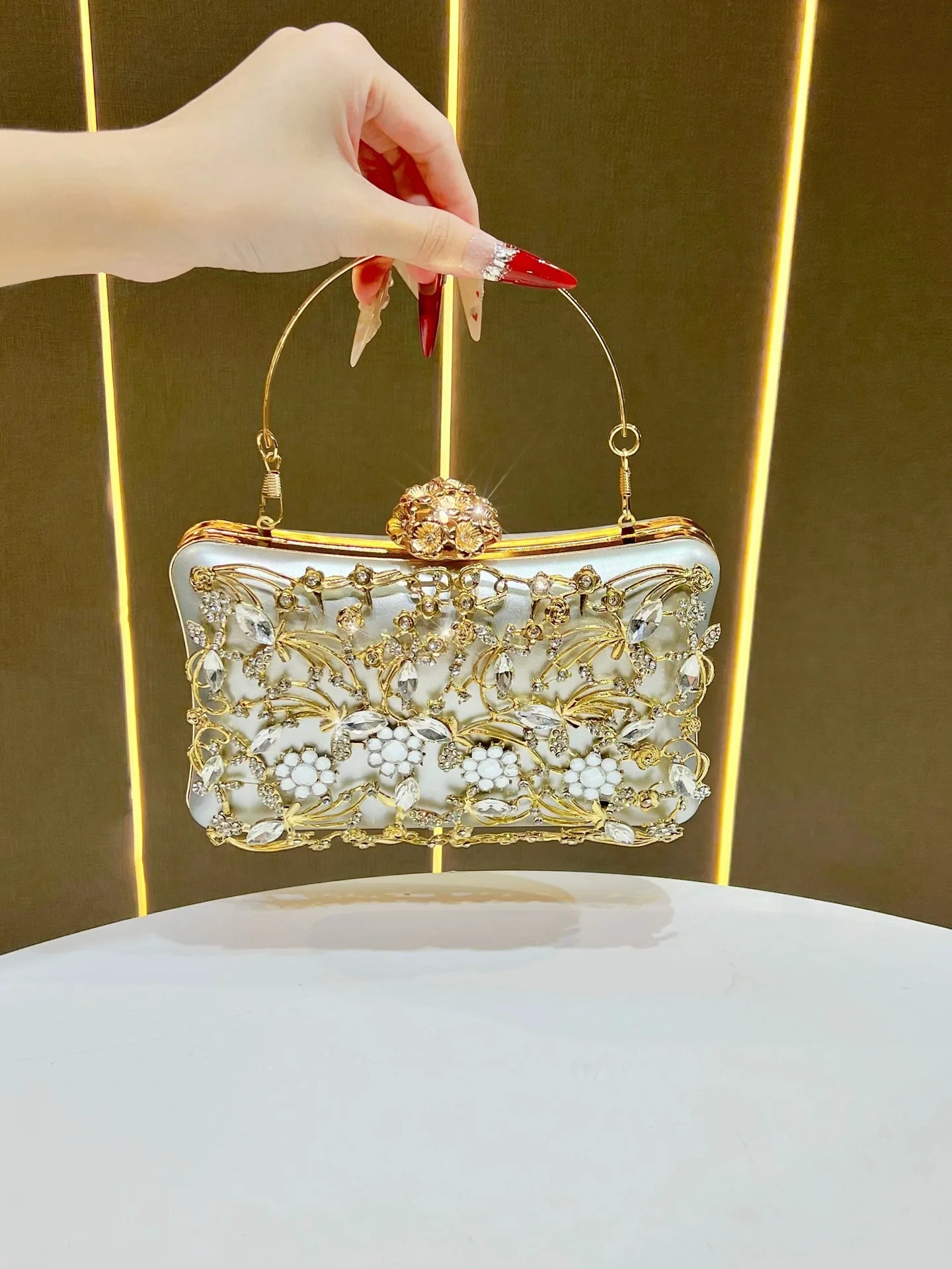 Edenista white diamond-embellished banquet bag with gold floral crystal motif and curved gold handle