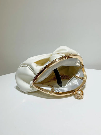 Edenista chain shoulder bag, white satin with knotted top, gold circular frame, chain, and pearl charm