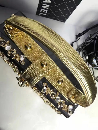 Edenista gold acrylic evening bag with rhinestone floral embellishments, Chanel box visible in background.