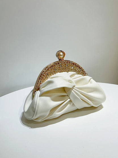 Edenista gold-tone crystal-embellished clutch with pearl clasp and ivory satin bow