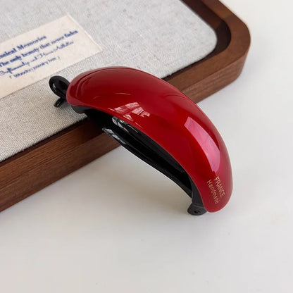 Red acetate high-ponytail clip by Edenista with black inner grip