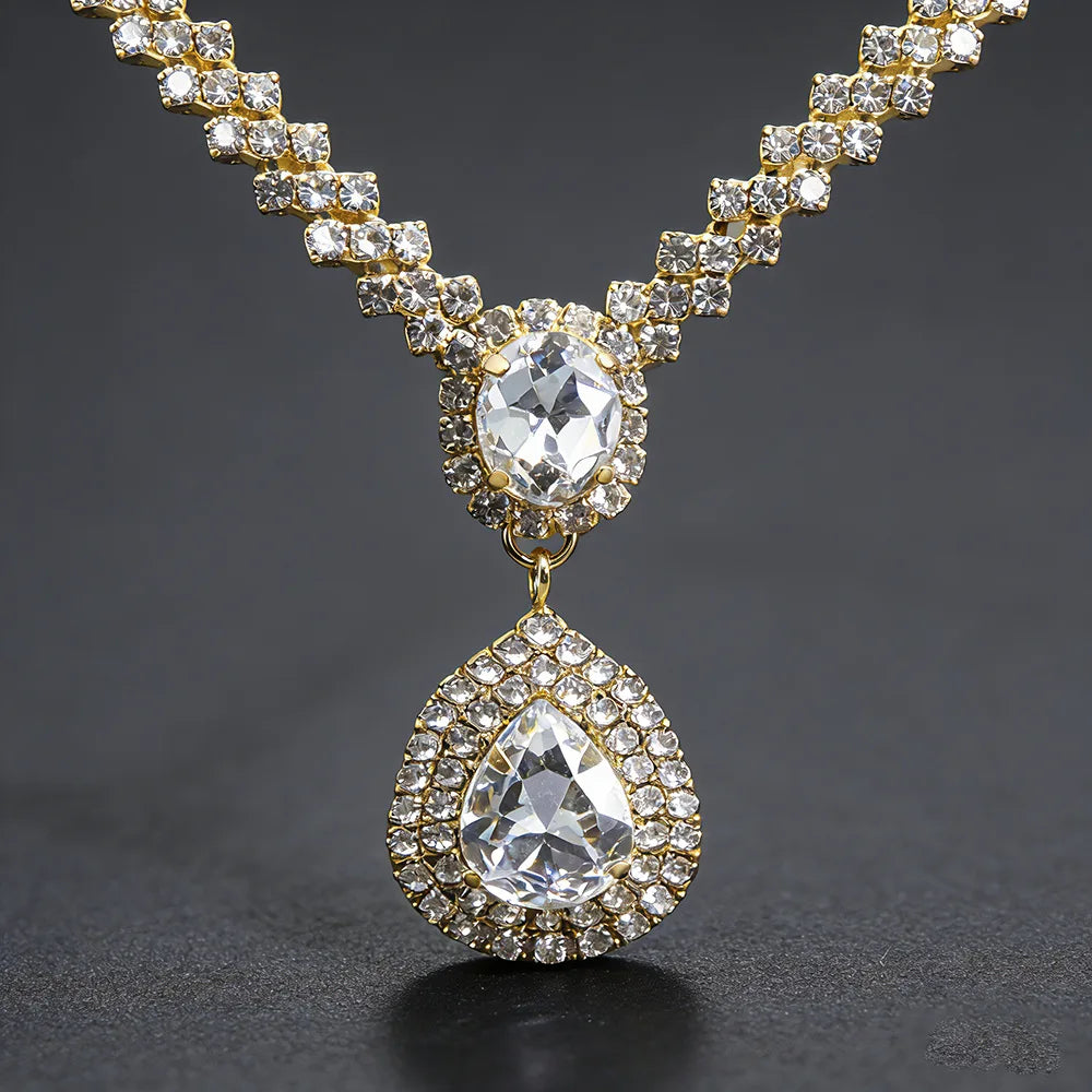 Diamond necklace with teardrop pendant and halo of stones in gold-tone setting