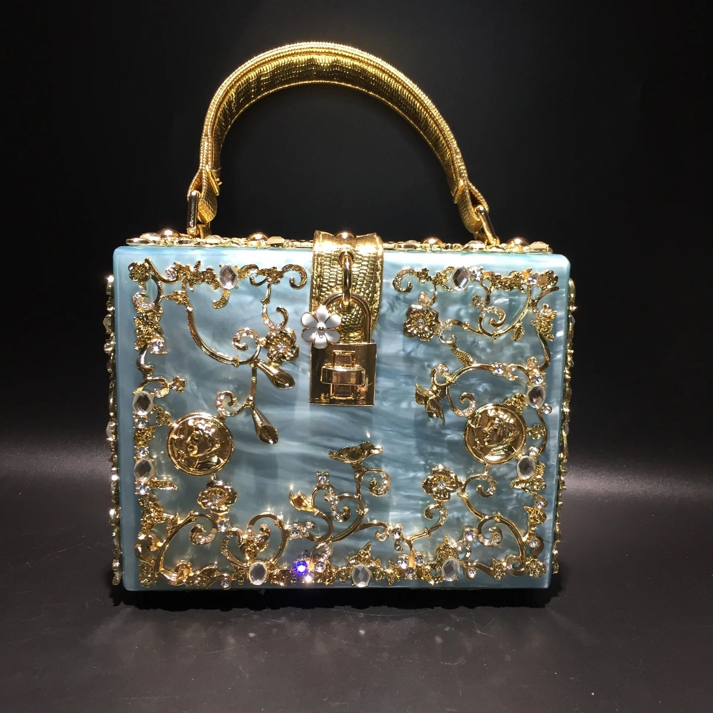 Acrylic evening bag by Edenista in blue with gold rhinestone filigree and crystal accents.