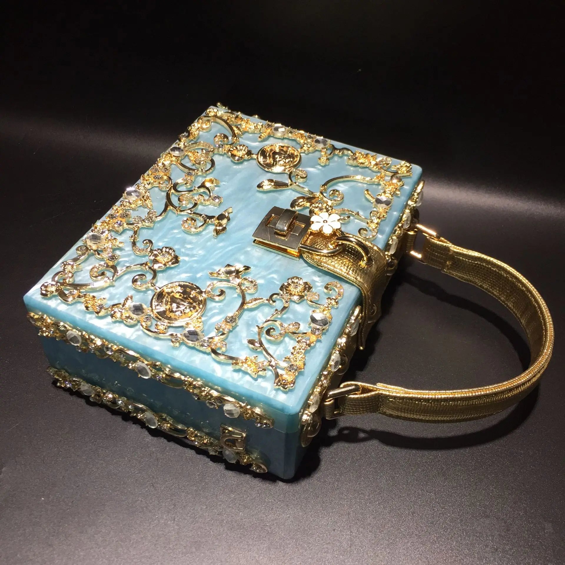Acrylic evening bag by Edenista with blue body and gold rhinestone filigree, gold chain shoulder strap