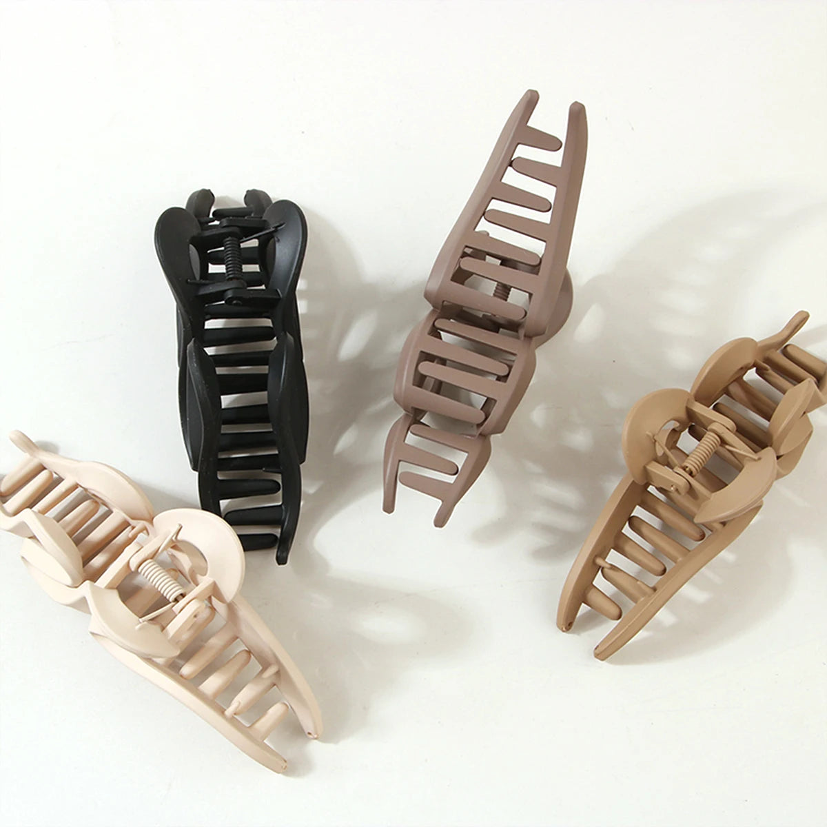 Edenista set of 4 large acrylic hair claw clips in black, coffee beige, and beige tones with geometric crab design