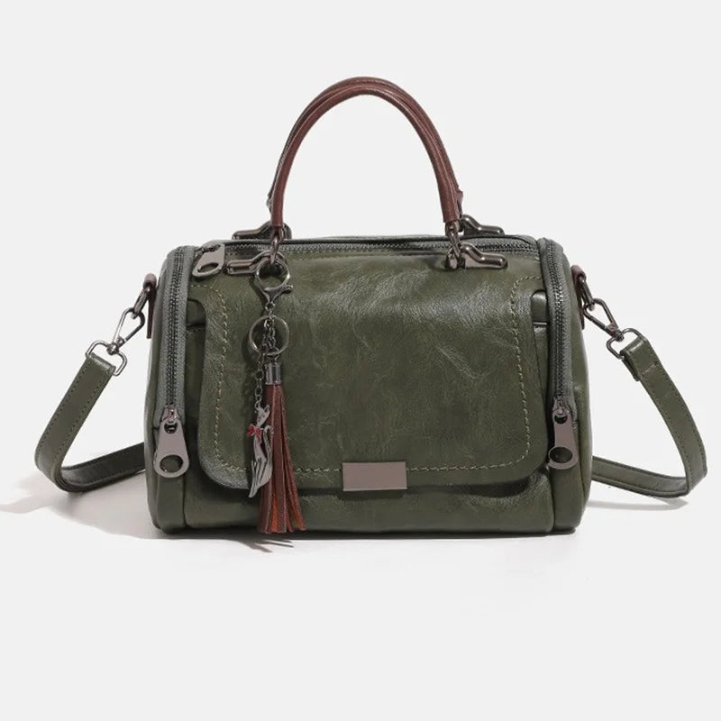 Olive green retro shoulder bag with brown top handle, tassel charm and floral pendant crossbody.