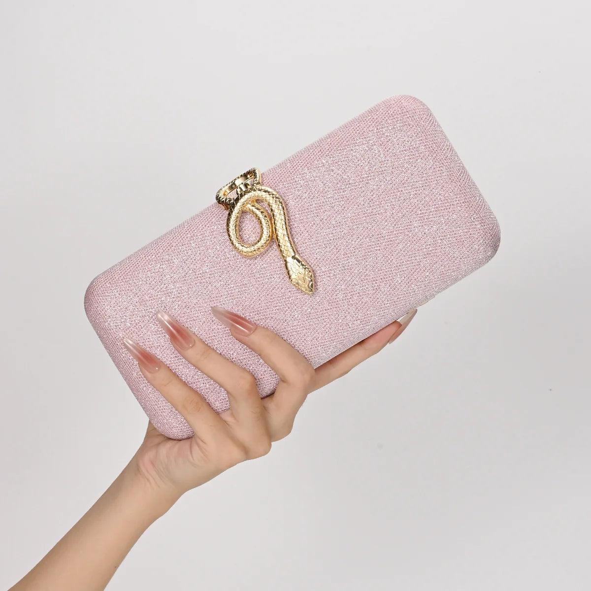 Clutch purse by Edenista in pink sparkling fabric with gold snake buckle, square box design.