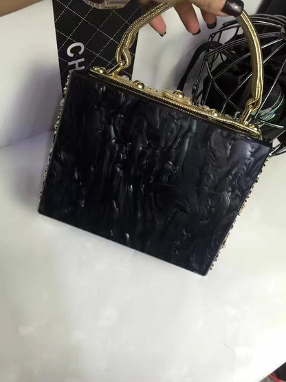 Edenista acrylic evening bag; black top-handle clutch with gold-tone frame and rhinestone accents