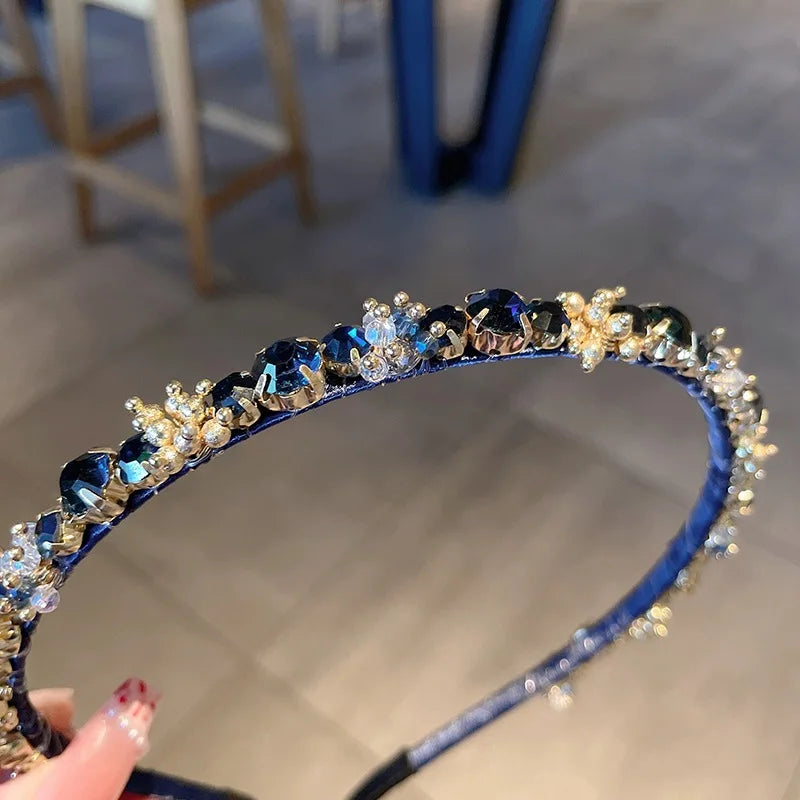 Edenista blue rhinestone headband with gold-tone settings and clear crystal accents.