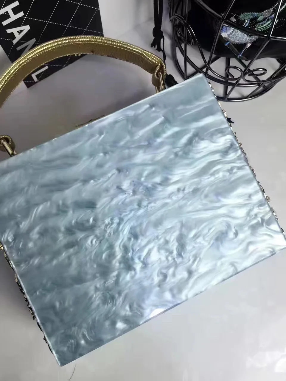 Light blue marbled acrylic evening bag with rhinestone trim and a gold handle, designer clutch for weddings.
