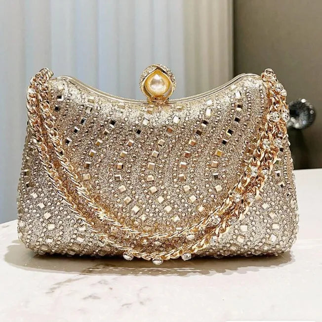 Gold-and-silver-tone rhinestone clutch with pearl clasp and chain strap, evening bag.
