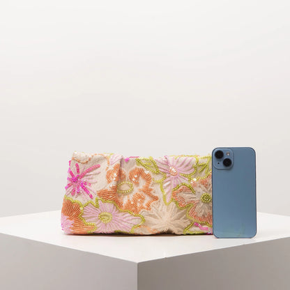 Edenista clutch bag with multicolor floral sequin embroidery beside a blue iPhone for scale
