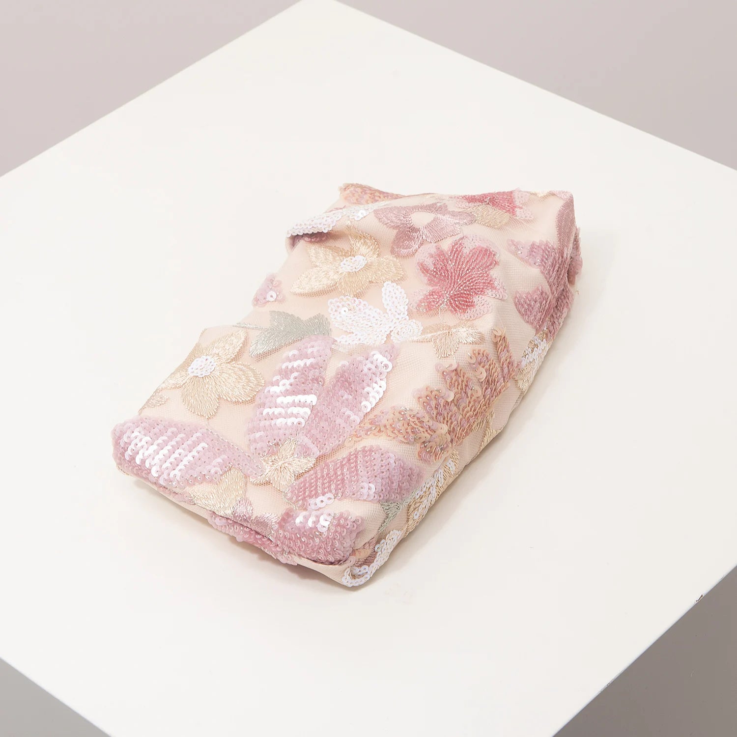 Clutch bag by Edenista with pink floral embroidery and sequin details.