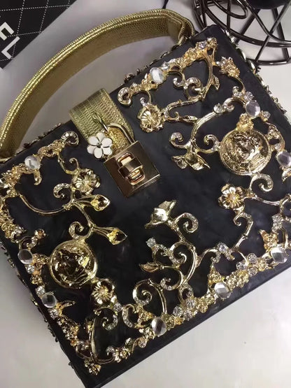 Edenista acrylic evening bag with gold rhinestone filigree on black clutch; crystal accents and gold handle