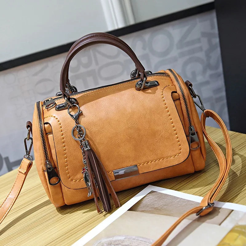 Shoulder bag, tan solid-color with floral pendant tassel, retro crossbody Boston style.