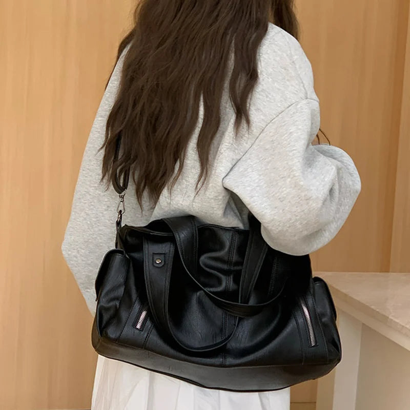 Women’s black leather tote bag with multiple pockets and large capacity for daily commuting