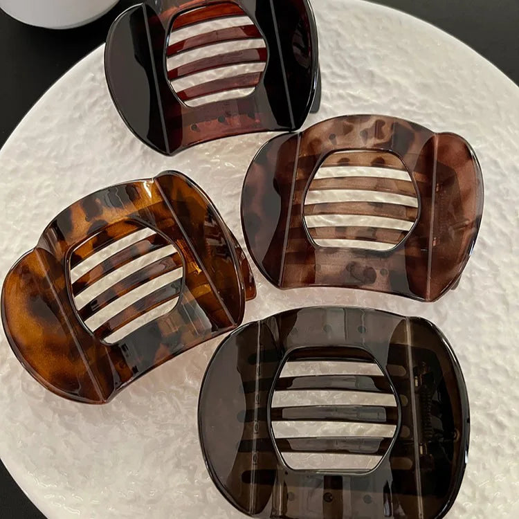 Four tortoiseshell flat crab hair clips with light horizontal center slats.