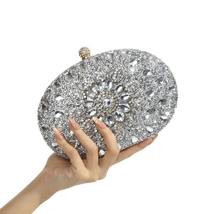 Crystal-embellished oval evening clutch with silver rhinestones, held in hand