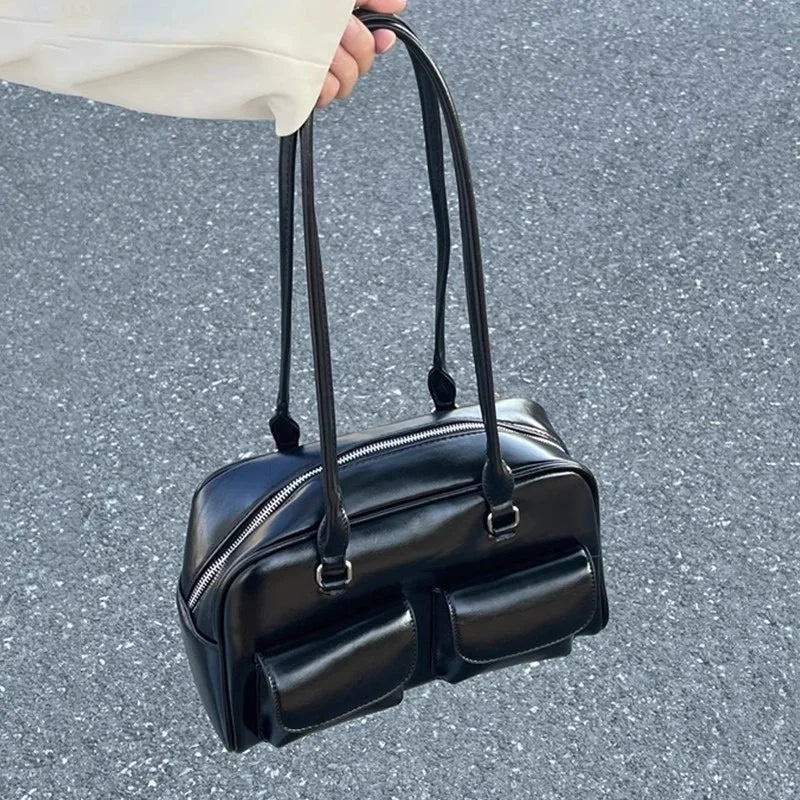 Women's black bowling bag with multiple front pockets and dual top handles