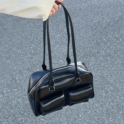 Women's black bowling bag with multiple front pockets and dual top handles