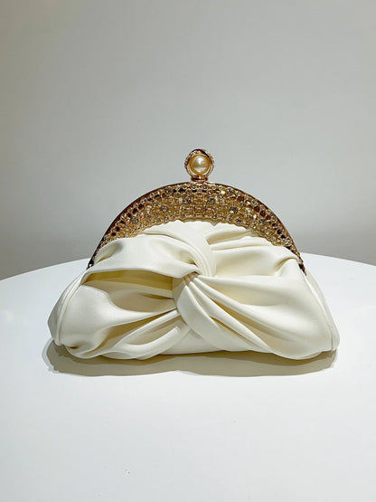 Gold-tone crystal-embellished evening clutch with pearl clasp on ivory satin knot bag
