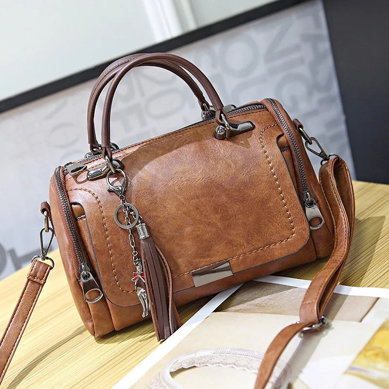 Brown faux leather retro shoulder bag with floral pendant and tassel decor, crossbody strap