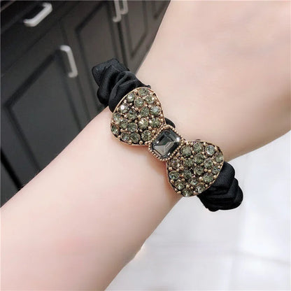 Fashion rhinestone bow scrunchie on black elastic band with two glittering bows.