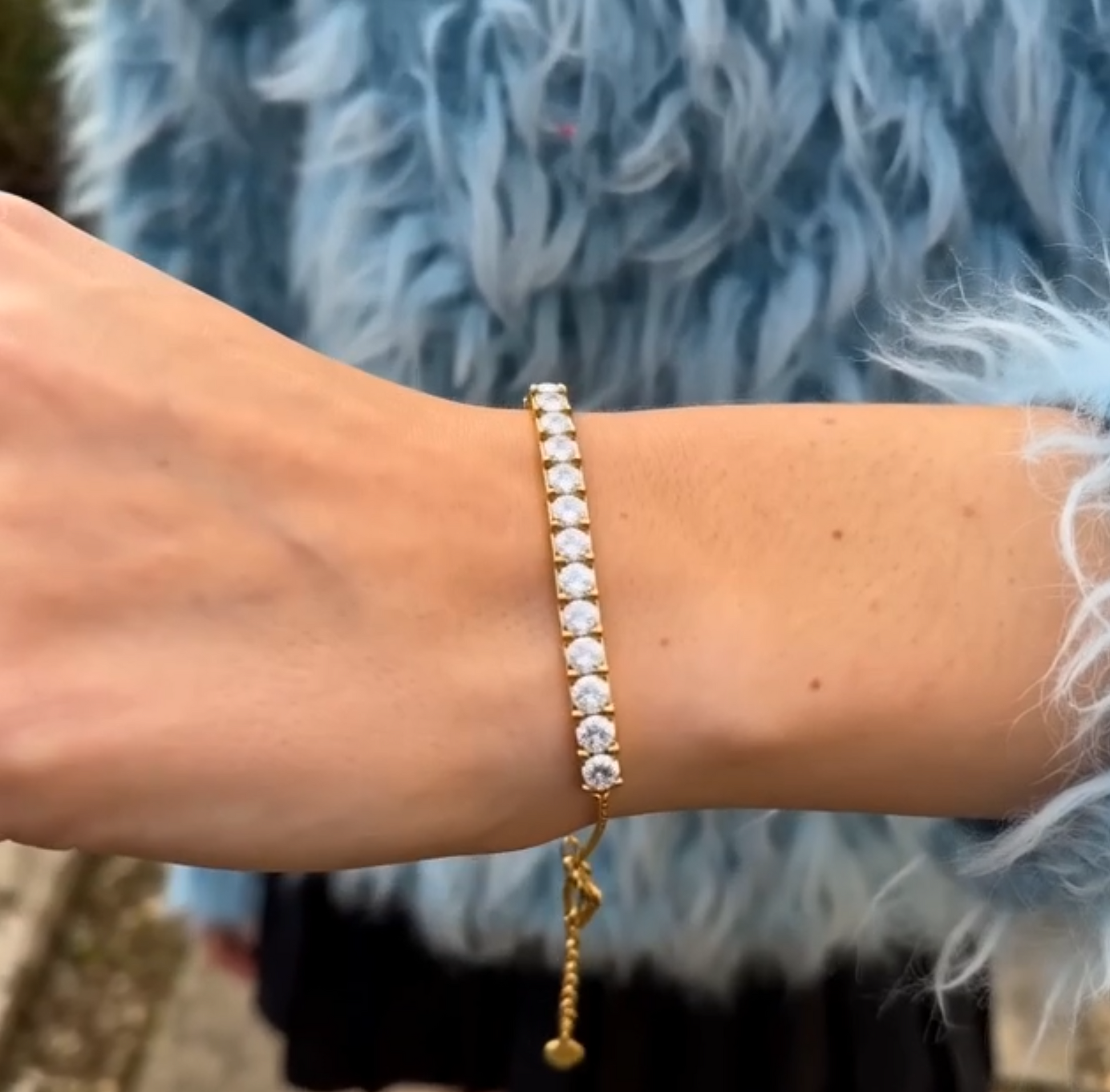 Gold-tone Edenista bracelet with clear square crystal stones on wrist