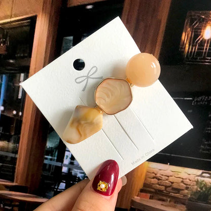 Geometric acrylic hair clip set with peach bead and marbled beige shapes on a gold-tone frame