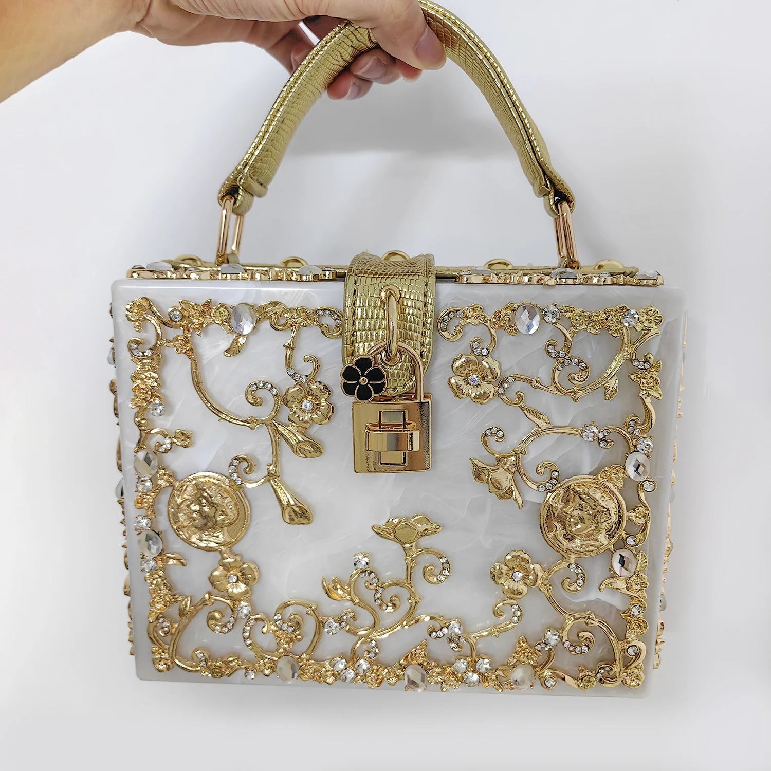Edenista acrylic evening bag with gold ornate filigree, rhinestones, and a gold handle clutch.