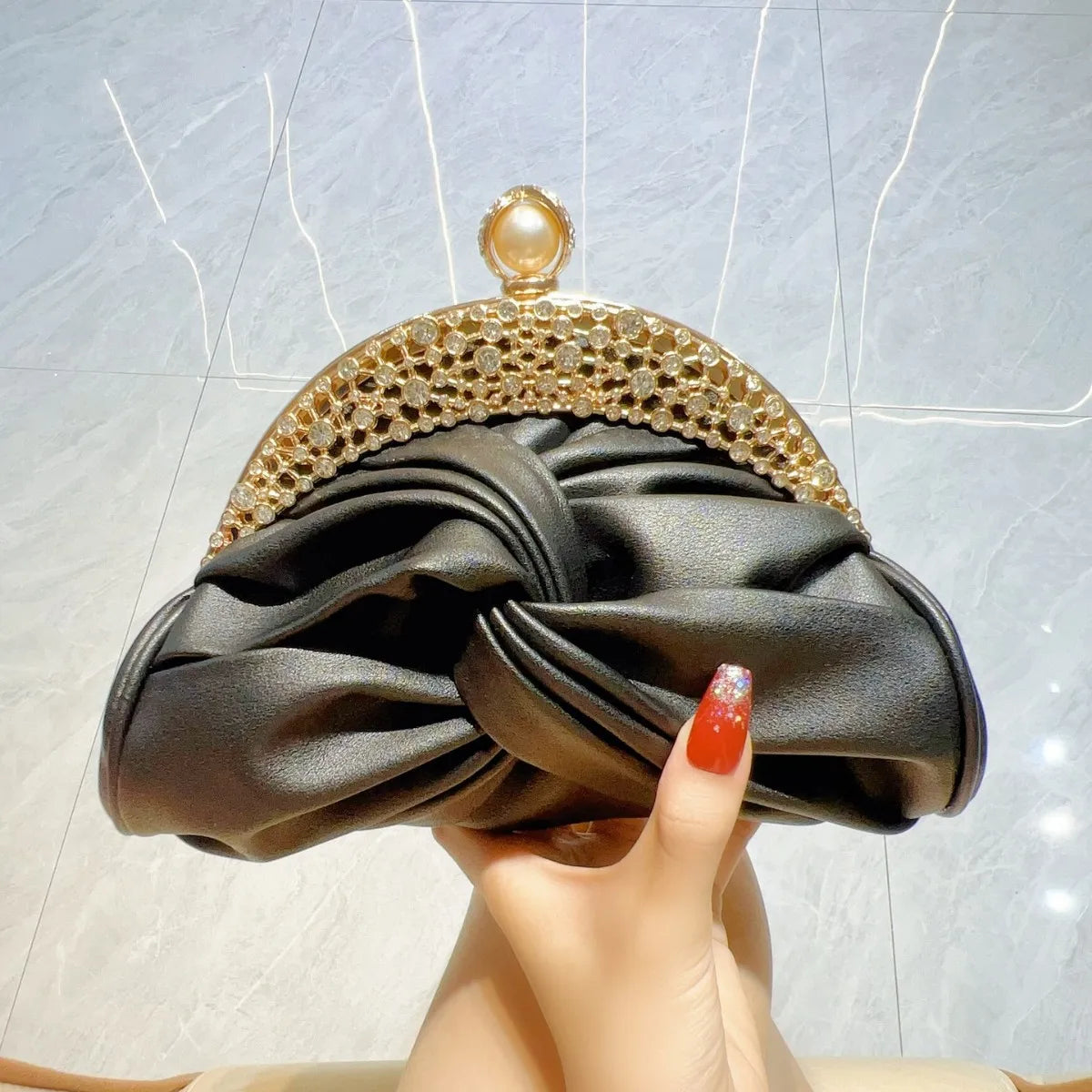 Clutch bag with black satin knot, gold-tone crystal frame, and pearl clasp
