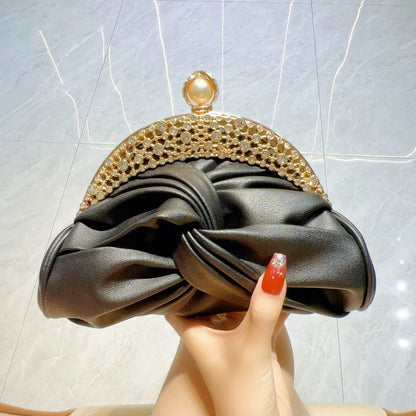Clutch bag with black satin knot, gold-tone crystal frame, and pearl clasp