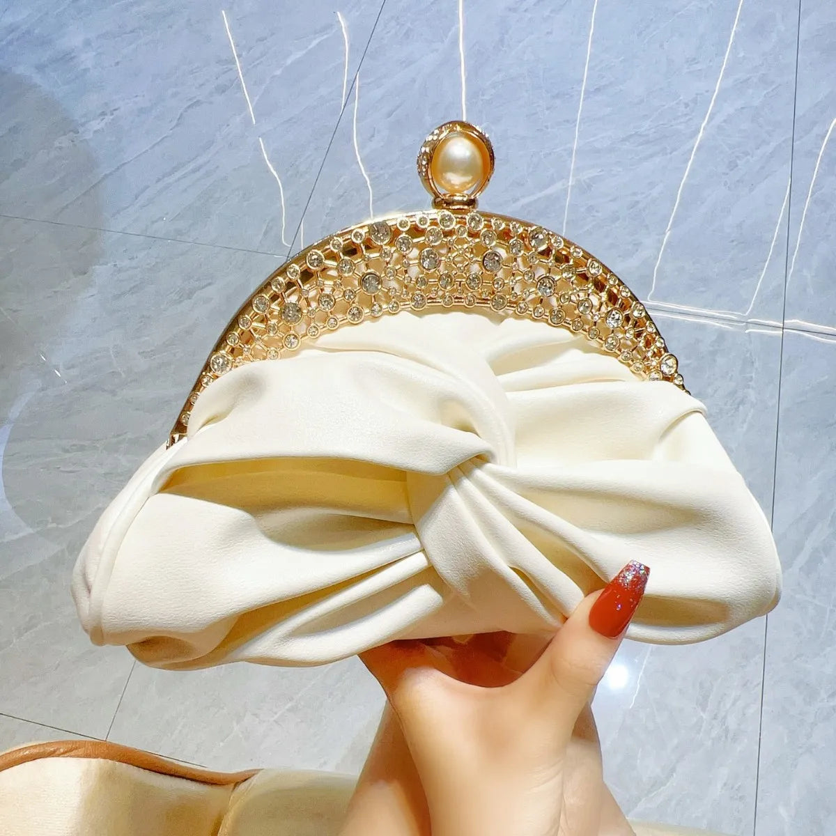 Edenista cream satin clutch with crystal gold frame, pearl knob, and bow