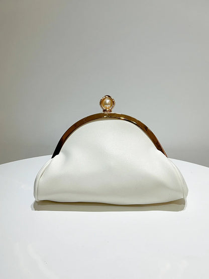 White clutch purse with gold-tone frame and pearl top clasp