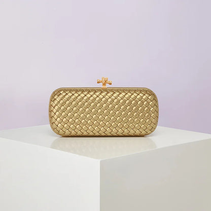 Gold woven box clutch bag with decorative clasp for evening wear.