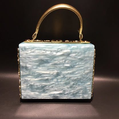 Edenista acrylic evening bag clutch with gold-tone rhinestone-trimmed handle and blue marbled body