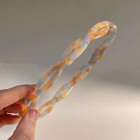 Acetic Acid Cross Minimalist Hairband; marbled orange and pale blue translucent plastic.