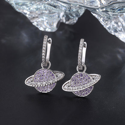 Silver earrings with purple gemstones on a dark background