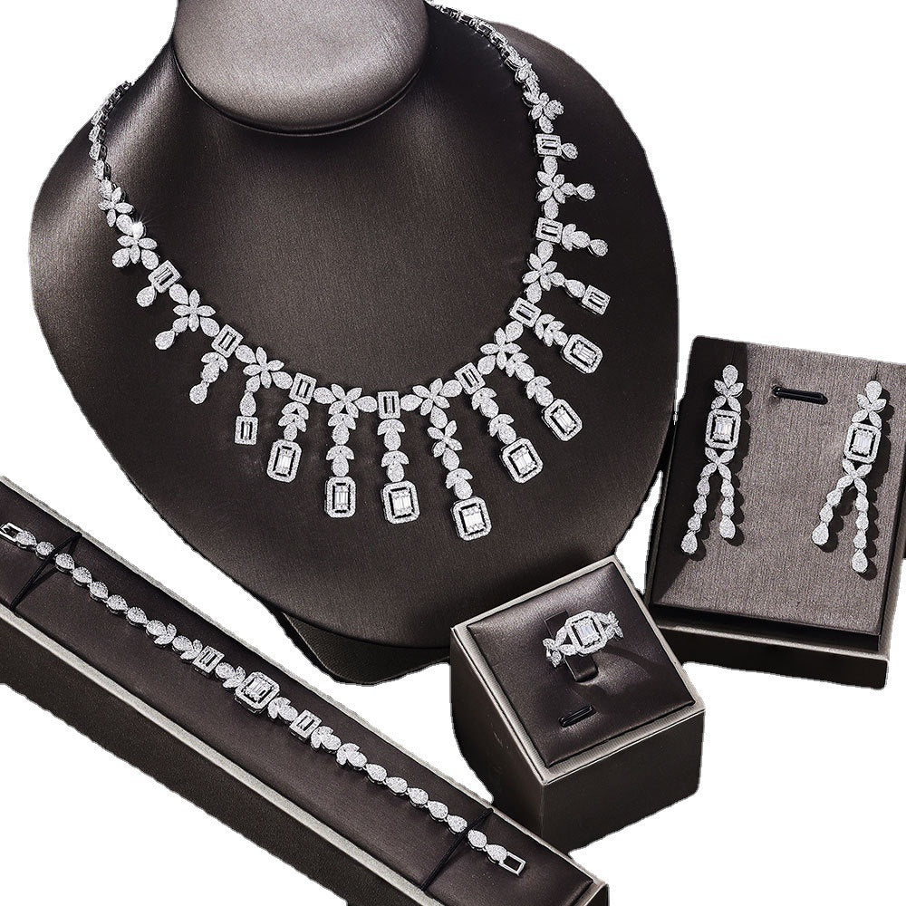Zircon jewelry set: necklace, earrings, bracelet, ring; silver-tone with clear stones, CJ brand, 4-piece set.