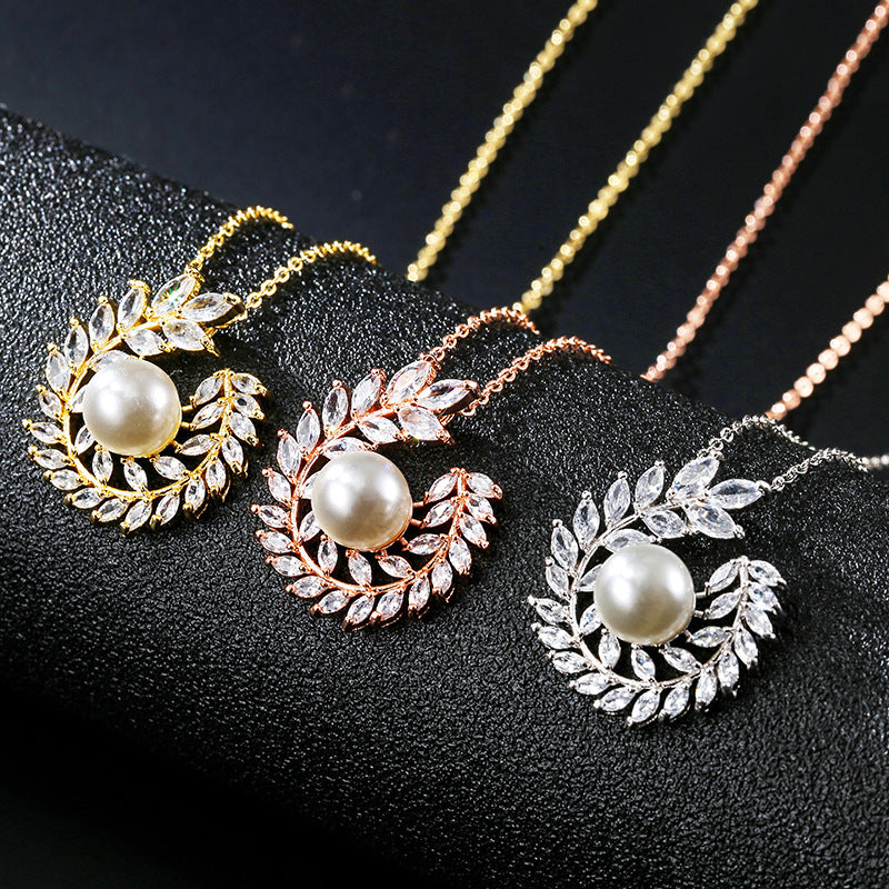 Set of three pearl pendant necklaces with laurel leaf halos in gold, rose gold, and silver by CJ