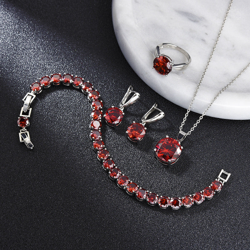 Geometric red gemstone jewelry set: bracelet, ring, earrings, and pendant necklace in silver-tone metal