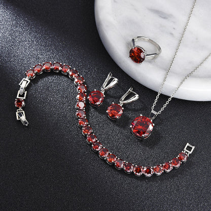 Geometric red gemstone jewelry set: bracelet, ring, earrings, and pendant necklace in silver-tone metal