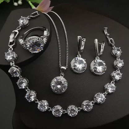 Silver-tone four-piece jewelry set with round crystal stones by cj: ring, necklace, bracelet, and earrings.