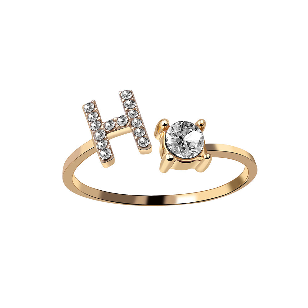 Adjustable gold-tone ring with crystal-encrusted H initial and a solitaire gem