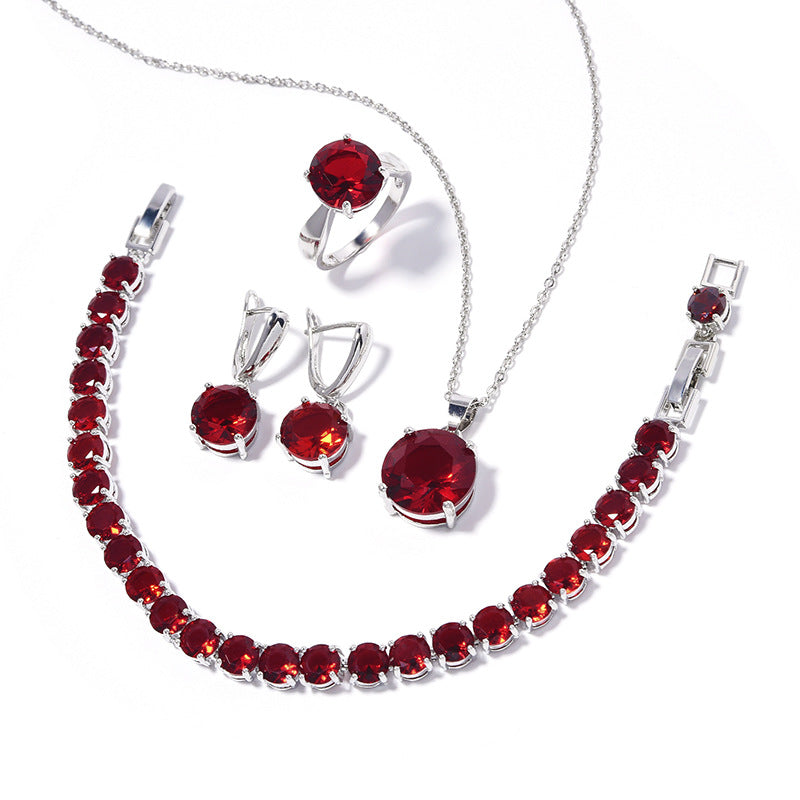 Geometric round red gemstone jewelry set featuring CJ necklace, bracelet, ring, and earrings in silver-tone