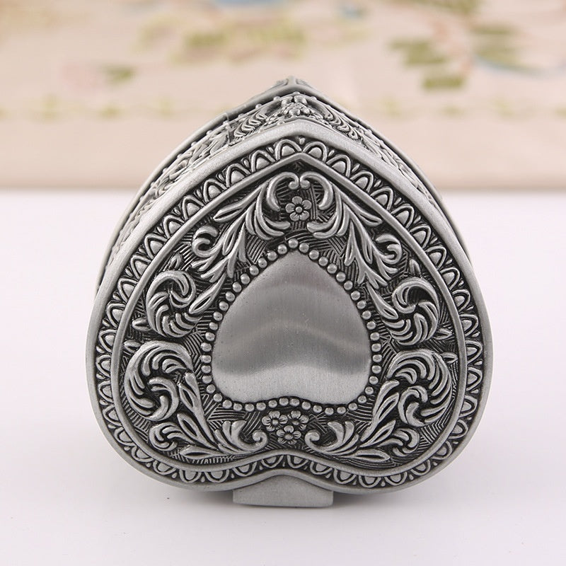 Heart-shaped jewelry storage box with ornate silver-tone engraving for brooches and rings, antique finish